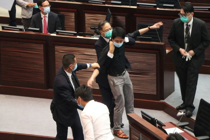 Ted Hui wordt weggeleid nadat hij met een vloeistof spoot en amok maakte in het parlement.
