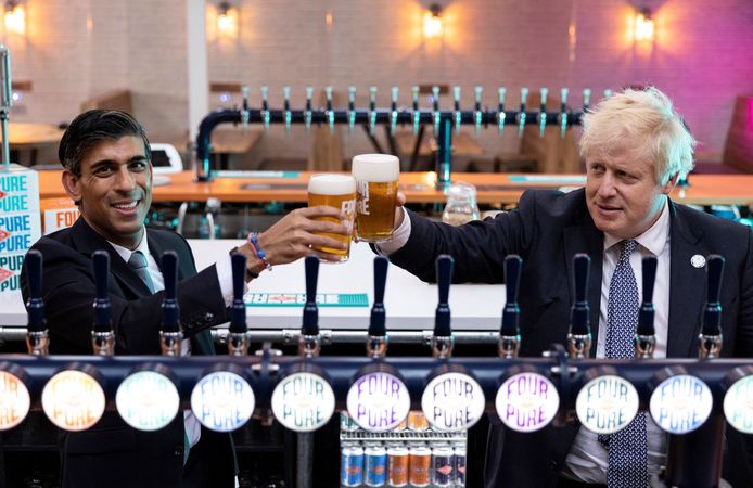 Boris Johnson en de Britse minister van Financiën Rishi Sunak (L) proosten met een bierje.