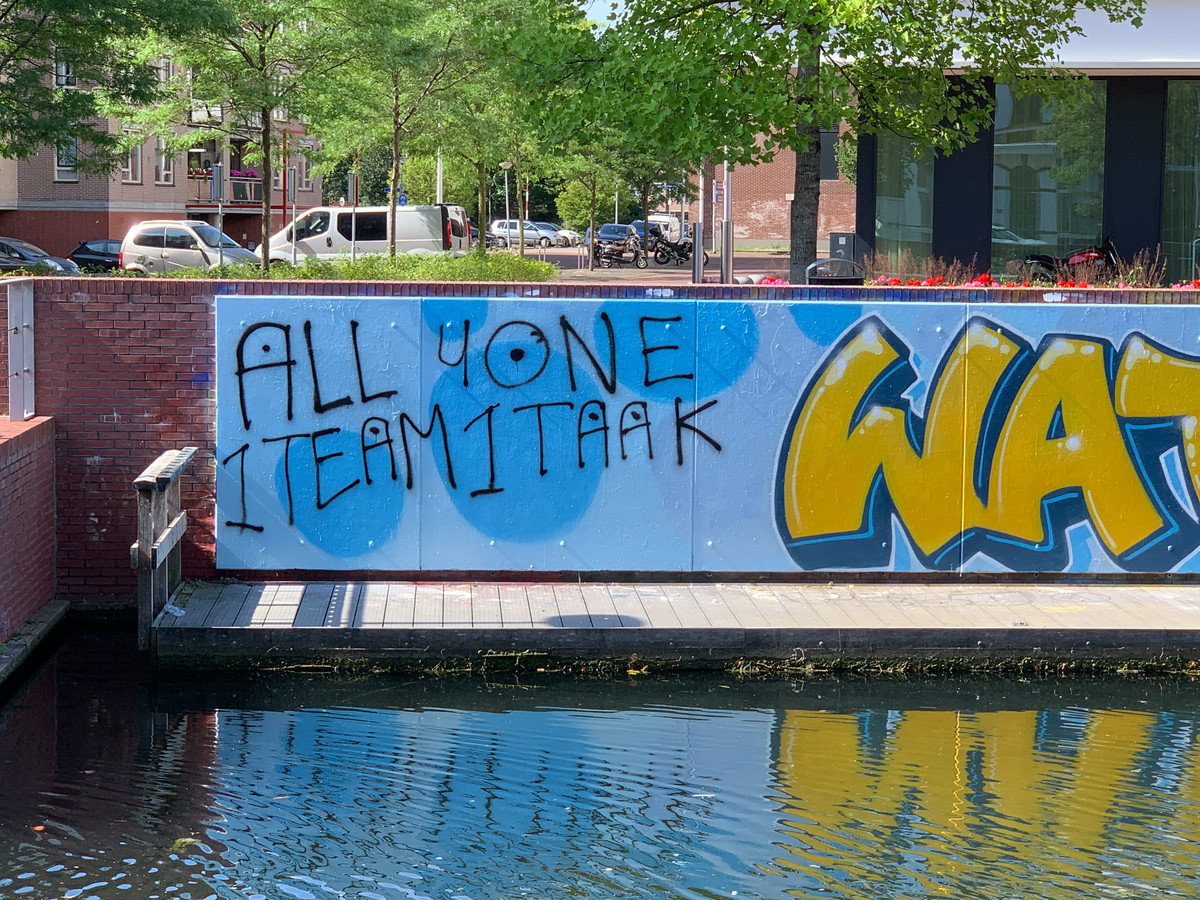 De nieuwe muurschildering bij het stadhuis in Almelo is na enkele uren beklad met de tekst 'All 4 one 1 team 1 taak'.