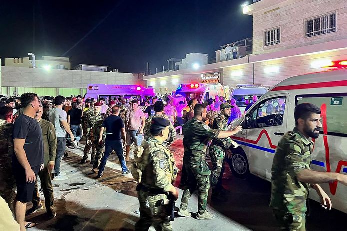 Hulpverleners en militairen bij de feestzaal in Hamdaniyah waar de brand uitbrak.