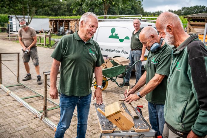 Tonnie van Hooff  (links) is coördinator van de werf en de werkplaats van landschapsbeheer Oss. De werf is de laatste maanden flink uitgebreid en opgeknapt. Hij is in gesprek met een aantal vrijwilligers.
