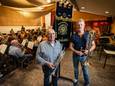 Voorzitter Hans Jurgen Oortmann (rechts) en Henk Veldboer van de jubilerende muziekvereniging Caecilia uit Ootmarsum bij het nieuwe vaandel van de 150-jarige vereniging.