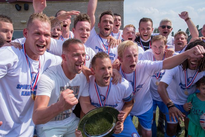Ruud Zuijderwijk heft de schaal met aanvoerder Koen Warners bij het kampioenschap van SC Monster in de derde klasse.