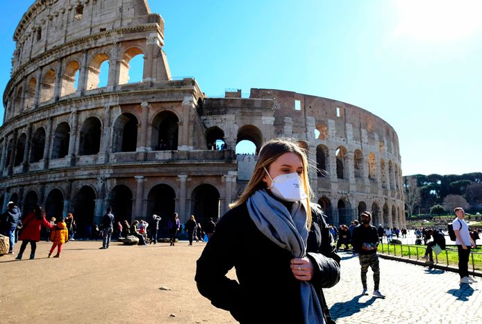 Une femme portant un masque devant le Colisée, à Rome.