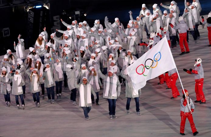 De Russische atleten lopen tijdens de openingsceremonie met de olympische vlag het stadion binnen.