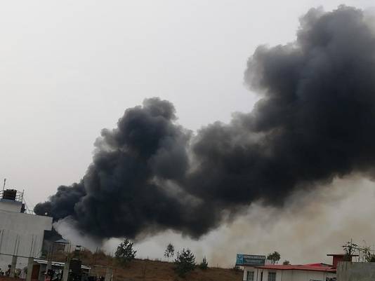 Boven het vliegveld van Kathmandu is een enorme rookwolk te zien