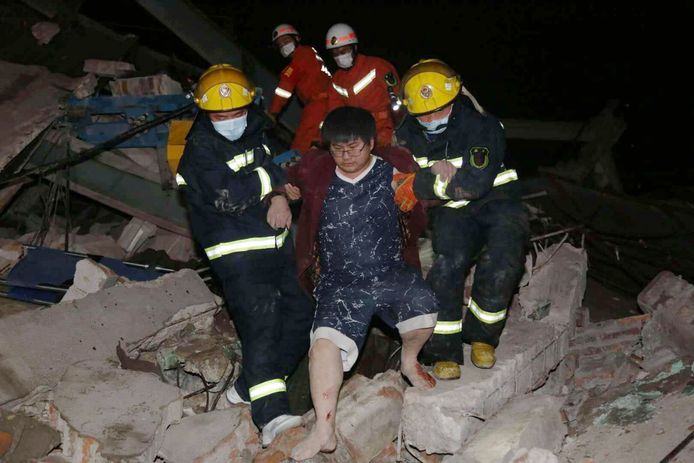 Een man wordt gered uit het puin van het ingestorte hotel.