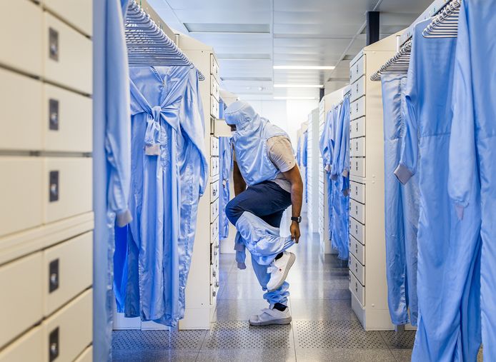 Een medewerker kleedt zich om in de fabriek van chipproducent NXP in Nijmegen. Het bedrijf kondigde donderdag aan banen te schrappen.