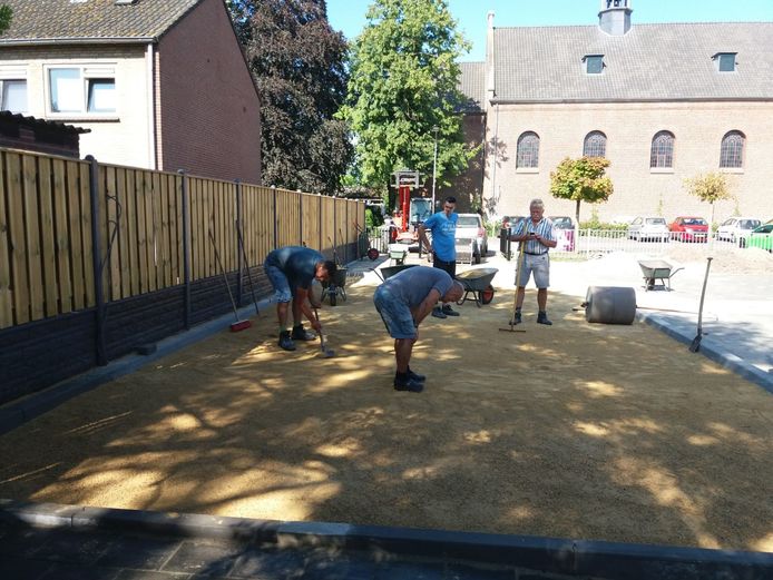 De vrijwilligers werken in de hete zon aan de aanleg van een dubbele jeu-des-boulesbaan in Langeweg
