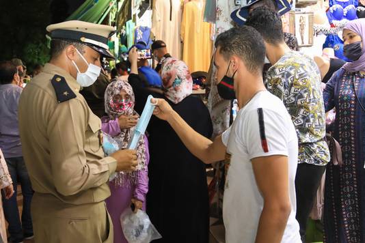Een politieman in Marrakech deelt mondmaskers uit in de strijd tegen de coronapandemie. (17/08/2020)