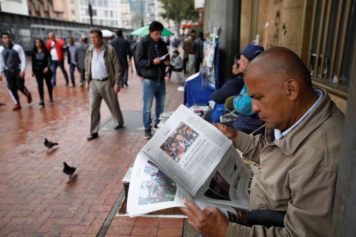 Een man leest een krant met daarin het nieuws dat er een tweede ronde komt in de Colombiaanse presidentsverkiezingen.