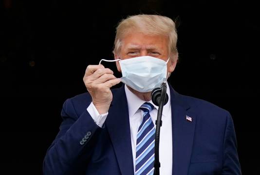 De Amerikaanse president Donald Trump doet zijn mondmasker af.