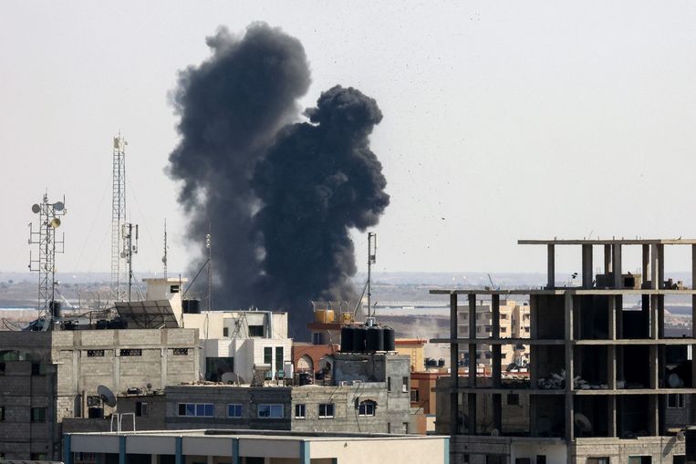 Rook stijgt op uit een gebouw in Rafah, op de zuidelijke Gazastrook, dat dit weekend werd gebombardeerd door het Israëlische leger.  Beeld AFP