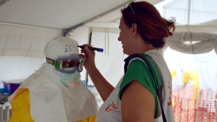 Een medisch werker in Monrovia krijgt haar naam op haar ebolapak geschreven. Beeld afp