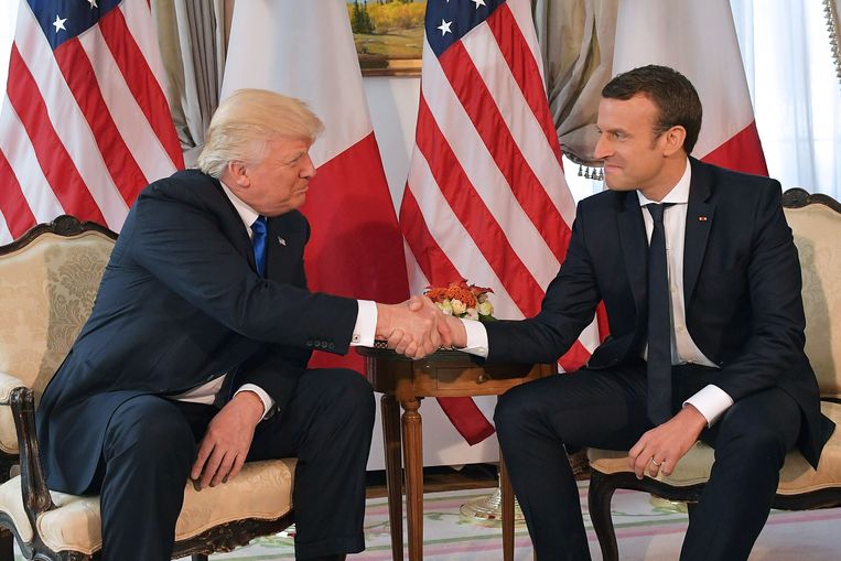 De Franse president Macron en de Amerikaanse president Trump drukten elkaar vorig jaar de hand tot hun knokkels wit werden.  Beeld AFP
