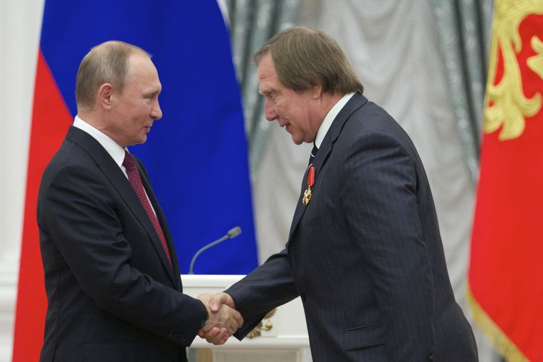 Putin shakes hands with his close friend Roldugin during a rally in 2016. ANP / AFP image