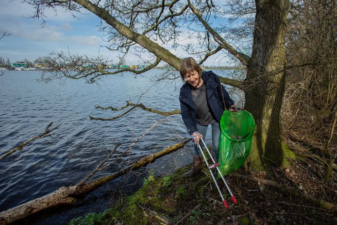Opruimen van troep rondom schiereiland Hanzeland. Astrid Eijgenberger (56) uit Maasbommel helpt mee.