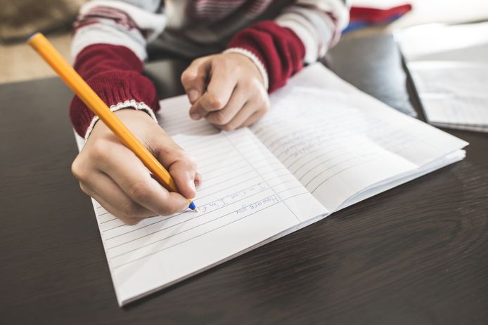 Een kind schrijft een brief.