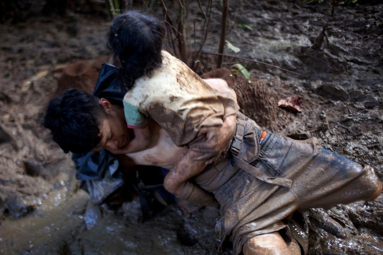 De kleine Joseyli houdt zich vast aan haar vader José, die in de modder gevallen is. Beeld Carlos Villalon