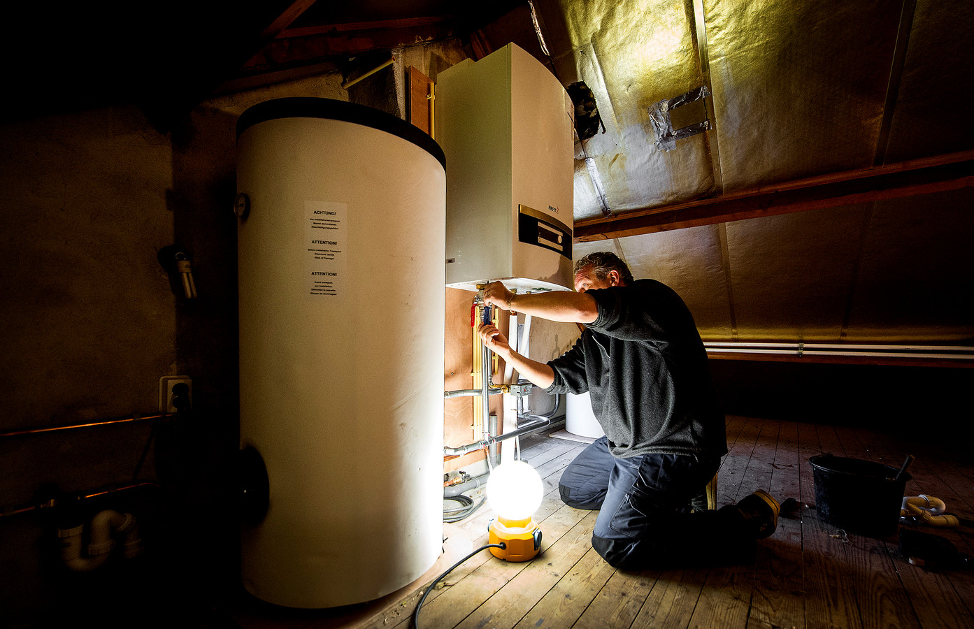 Een installateur aan het werk om een warmtepomp te installeren.