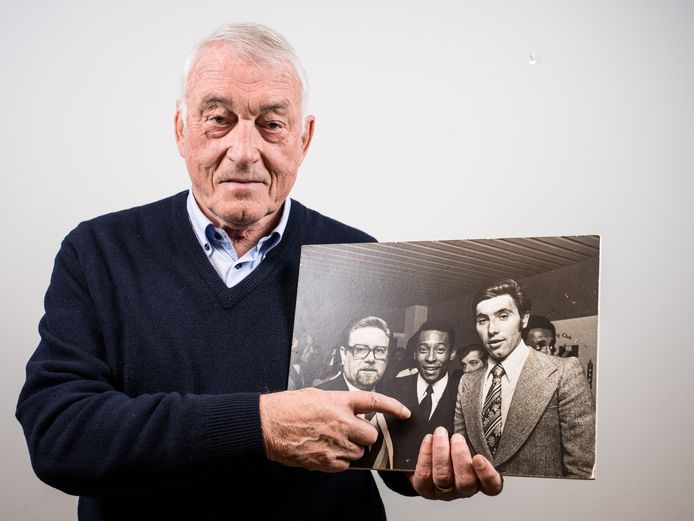 Paul Van Himst houdt in zijn kantoor de foto met Pelé en Eddy Merckx vast.