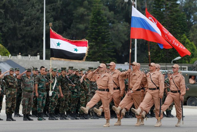 Russische soldaten tijdens een ceremonie met Syrische soldaten op de Syrische luchtmachtbasis Latakia.