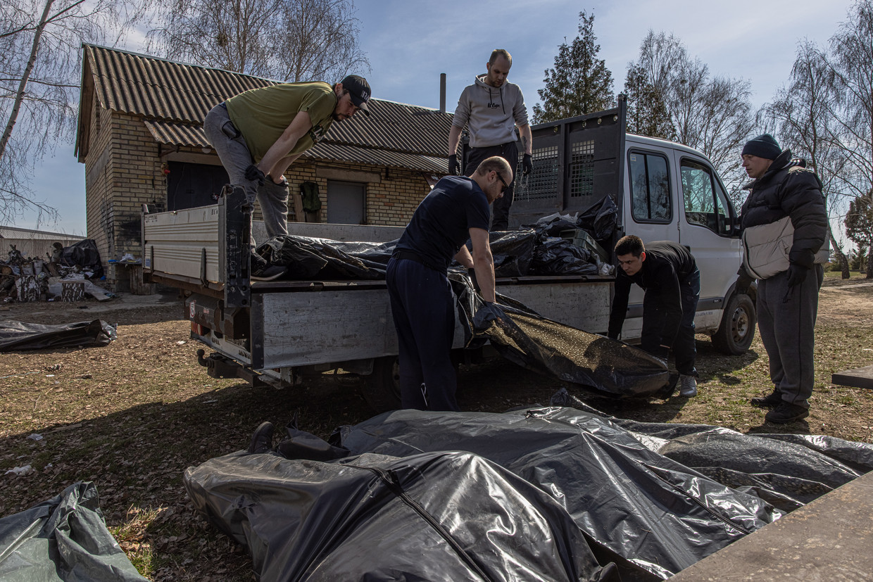 Vrijwilligers helpen met het transporteren van de lijken die werden achtergelaten in Boetsja. Beeld ANP / EPA