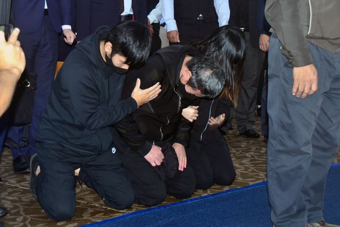 Yu Cheng-chung (midden), de machinist van de Puyuma Express die op 21 oktober ontspoorde, knielt samen met enkele familieleden van slachtoffers neer tijdens een herdenkingsdienst.