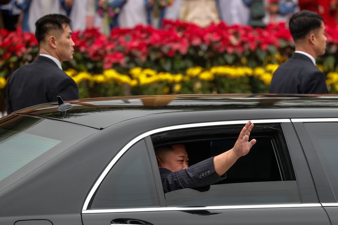 Kim zwaait vanuit zijn gepantserde limousine waarmee hij doorreist naar Hanoi.