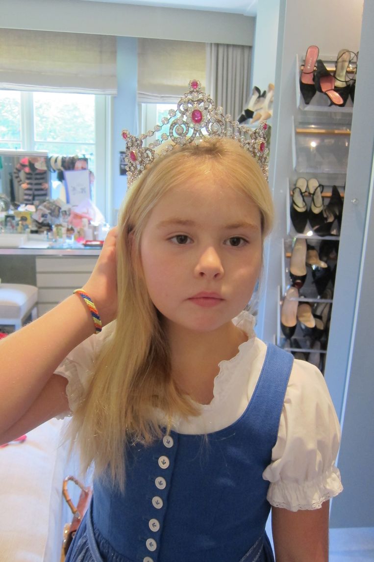 Amalia kent alle tiara’s van de Europese koningshuizen uit haar hoofd, maar geen een zo goed als de kluis van de Oranjes. Tijdens een opmaaksessie met mama past ze alvast even een loodzwaar exemplaar, met gepaste serieusheid, 2012. Beeld Koninklijk Huis