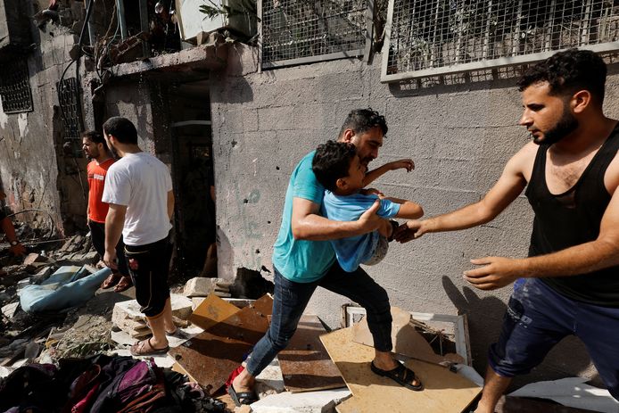 Een Palestijnse man evacueert een jongen na een Israëlische luchtaanval op een huis in het noordelijke deel van de Gazastrook.