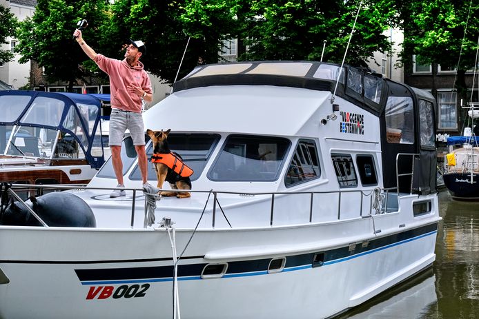 Kees Aantjes met hond Chiko op zijn boot.