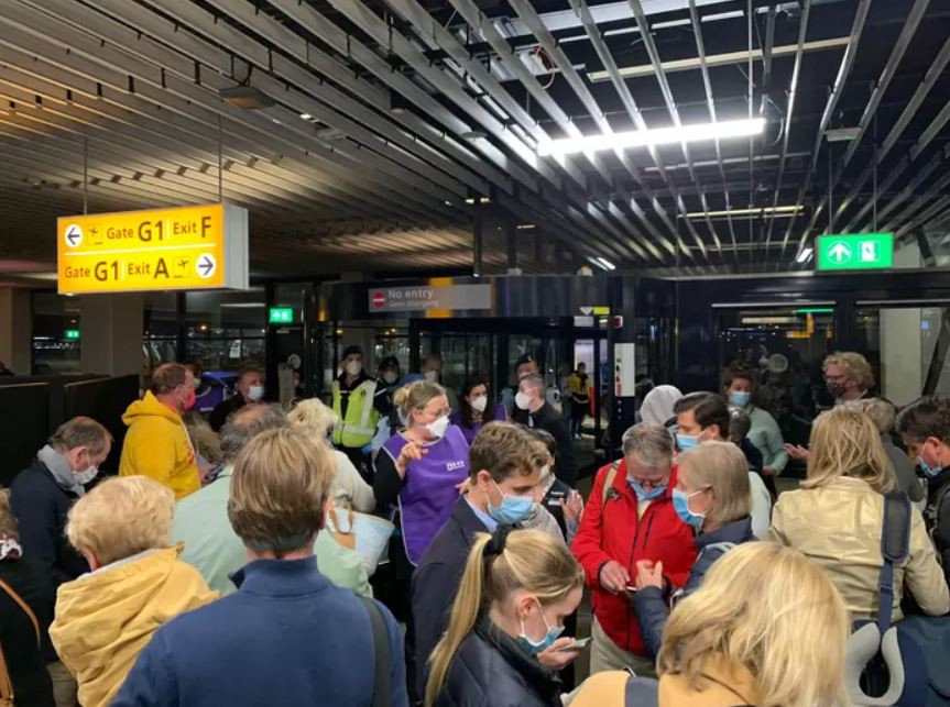 Een chaotische situatie op Schiphol na aankomst van de passagiers uit Zuid-Afrika.