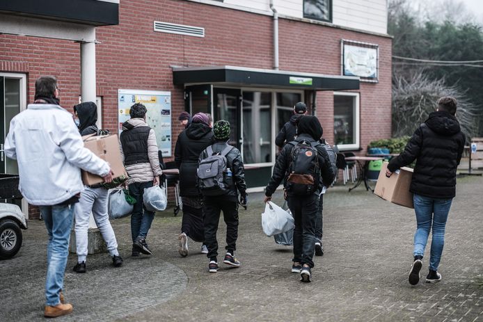 Gepakt en bezakt en met hulp van begeleiders lopen de jonge asielzoekers naar hun onderkomen op De Betteld, wat de komende vier maanden hun thuis zal zijn.