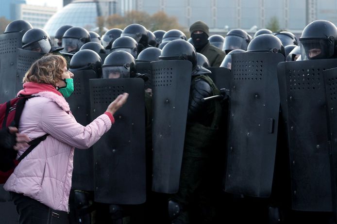 Een vrouw uit haar ongenoegen tegen de oproerpolitie die massaal waren uitgerukt tijdens de protesten tegen president Loekasjenko in de Wit-Russische hoofdstad Minsk op zondag.