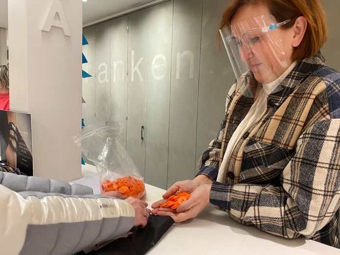 Noor Franken overhandigt de muntjes aan een collega-winkelier in Bergeijk die deelneemt aan de actie voor de Bergeijkse horeca.