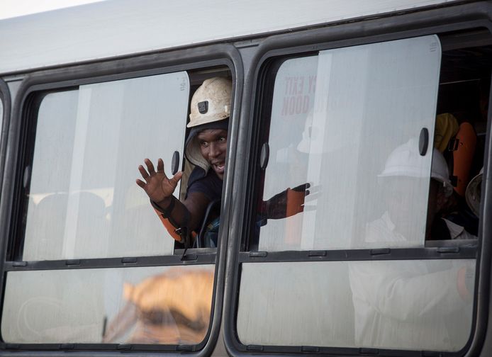 Een bus voert een groep geredde mijnwerkers weg.
