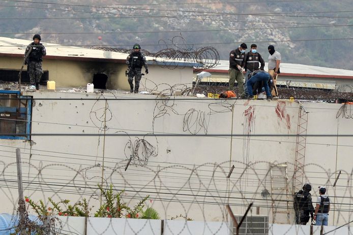 Polisi mengurung mayat seorang tahanan di dinding kompleks penjara di kota Guayaquil, Ekuador, di mana sedikitnya 68 orang tewas dalam pertempuran sengit pada Sabtu.