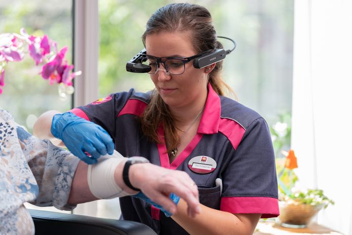 Vera Christiaansen, verpleegkundige in het verpleegkundig interventieteam van Zorggroep Ter Weel in Goes, demonstreert de smart glasses bij een cliënte.