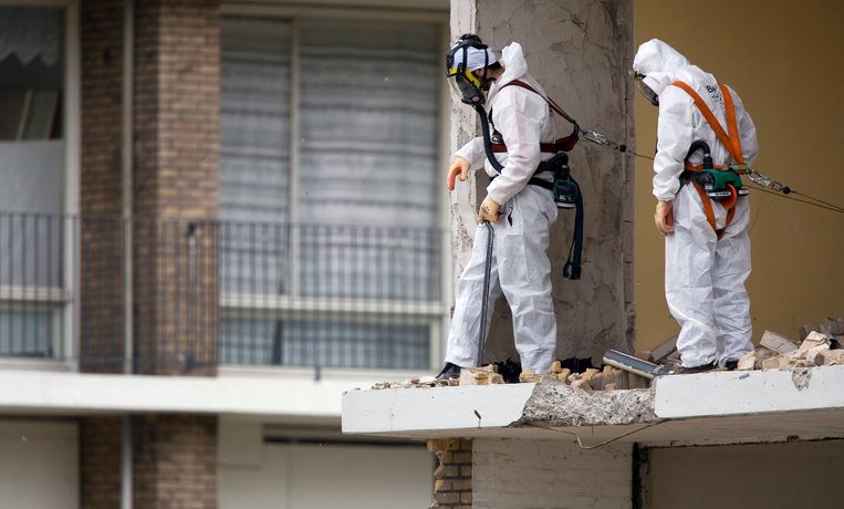 Werknemers met beschermende kleding verwijderen asbest.
Foto: ANP, Lex van Lieshout Beeld ANP XTRA