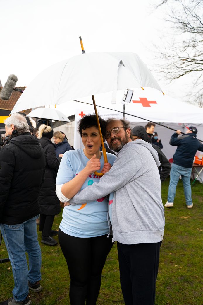 Waldek (Bart Van Avermaet) en Nora (Amara Reta) schuilen voor de regen.