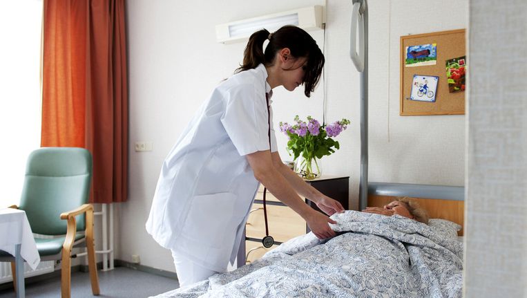 Een dokter neemt een kijkje bij een zieke vrouw. Beeld anp