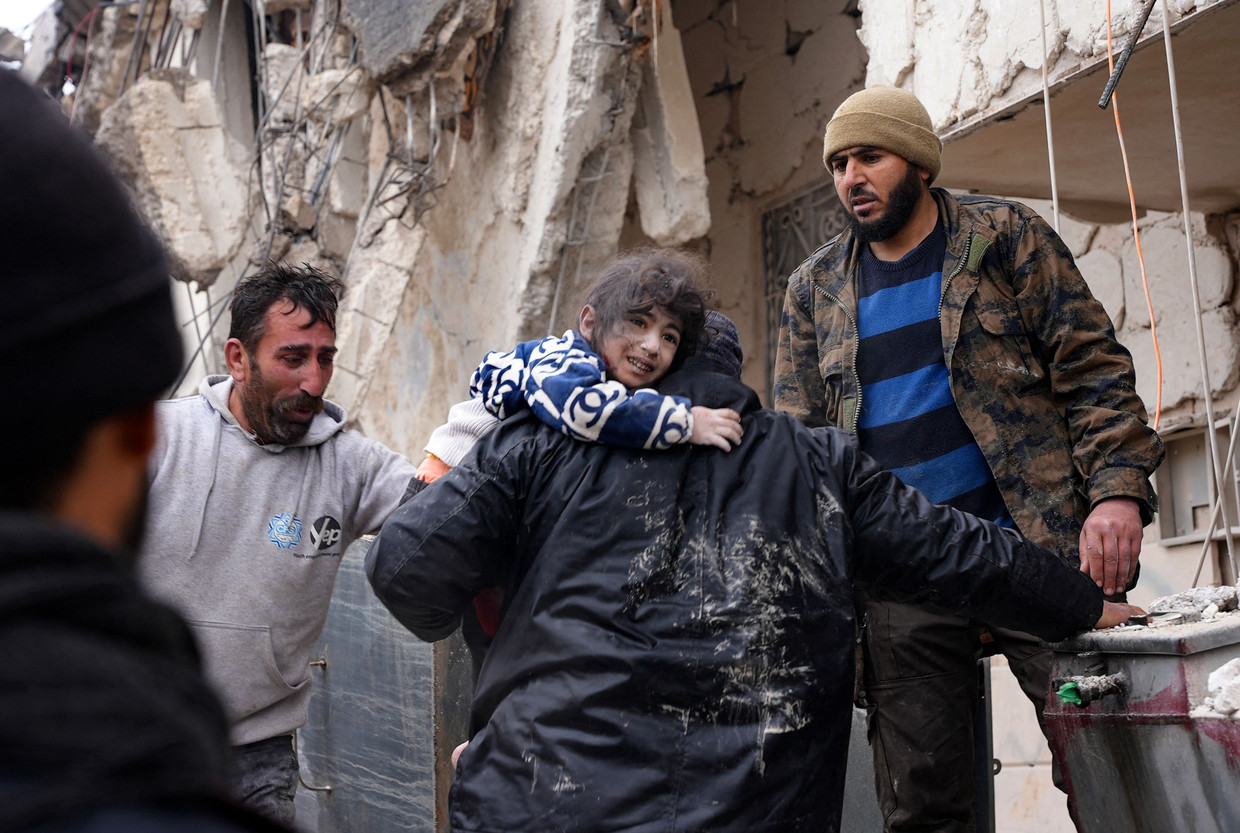 Bewoners halen een kind vanonder het puin van een ingestort gebouw in de stad Jandaris, in het door de rebellen gecontroleerde deel van de provincie Aleppo. Beeld AFP