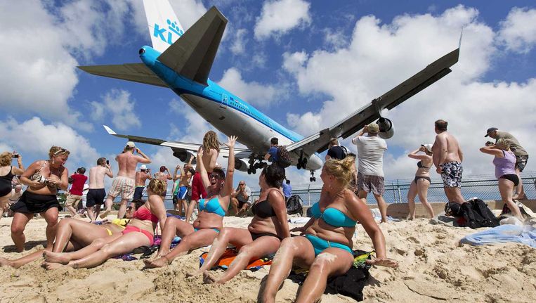 Een KLM-vliegtuig met daarin koning Willem-Alexander en koningin Maxima vliegt over het strand voor aankomst op de luchthaven van Sint Maarten in 2013. Beeld ANP