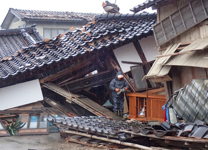 Naoki Teraozi probeert nog iets te redden uit zijn ingestorte huis in Nanao in de prefectuur Ishikawa.