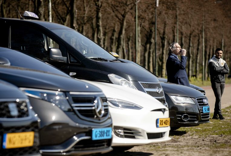 Taxiondernemers verzamelen zich op het Malieveld in Den Haag om een petitie te overhandigen op het ministerie van economische zaken. Beeld ANP 