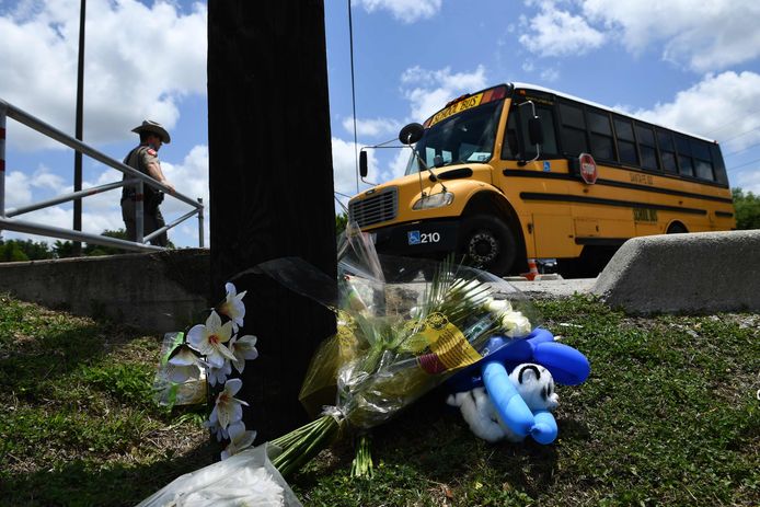 Mensen leggen bloemen neer aan de middelbare school in Santa Fe waar vrijdag een 17-jarige student tien medeleerlingen neerschoot en tien anderen verwondden.