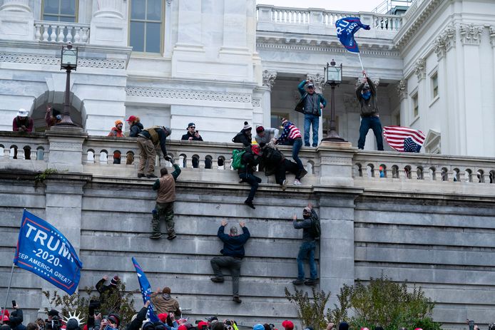 Demonstranten klimmen op de muren om binnen te geraken.
