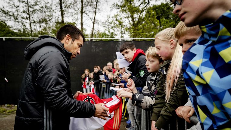 Giovanni van Bronckhorst deelt handtekeningen uit bij een trainingswedstrijd. Beeld anp
