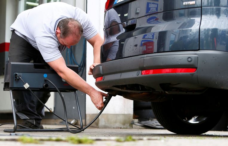 Een Duitse monteur meet de uitlaatgassen van een dieselauto.  Beeld Reuters
